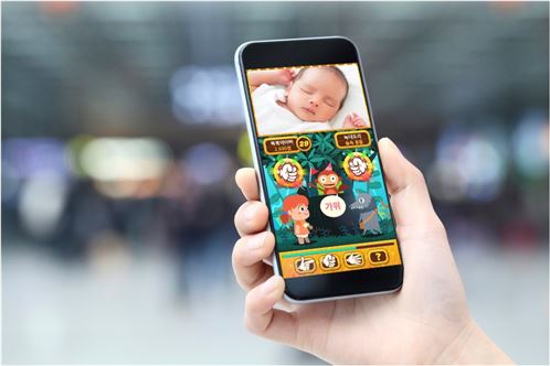산모 가족이 스마트폰의 '남양베베캠' 어플리케이션을 통해 신생아실 아기의 모습을 보고 있다.