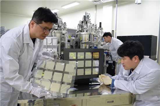 ETRI 연구원들이 세계 최대크기 그래핀을 이용한 OLED  패널(크기 : 370x470 mm) 시연하고 있다.