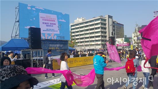 15일 서울 광화문 광장에서 한반도 전쟁위기조장 중단 긴급평화행동 집회 참가자들이 분홍띠를 들고 퍼포먼스를 펼치고 있다.