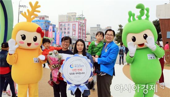 대전에서 온 김주홍씨 가족이 완도국제해조류박람회 10만 번째 관람객으로 입장해 신우철 조직위원장과 기념사진을 찍고 있다.
