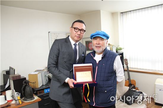 롯데제과가 역대 최고 CM송을 만든 가수 김도향씨(오른쪽)에게 감사패를 전달하고 함께 사진을 찍고 있는 모습.