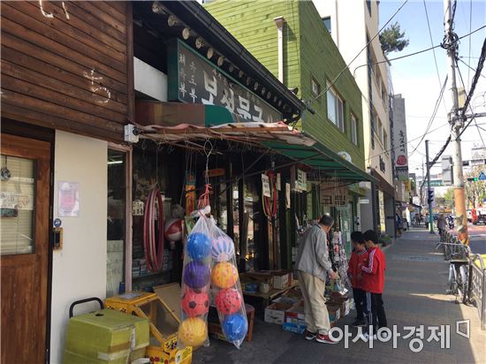 아이들이 옷걸이에 걸린 딱지를 보고 문구점 앞에 멈춰섰다.