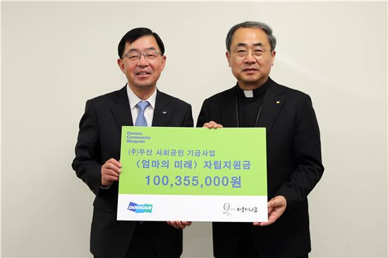 ㈜두산 박완석 부사장(왼쪽)이 재단법인  바보의나눔 손희송 이사장에게 미혼모 자립지원금을 전달하고 있다.