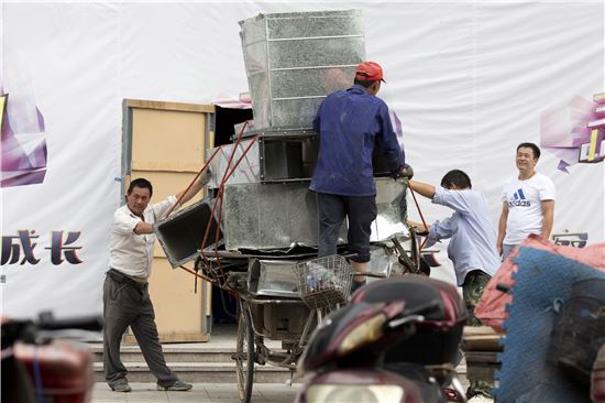 ▲중국 베이징 시내 공장에서 직원들이 알루미늄으로 만든 환기구를 옮기고 있는 모습. 미국 알루미늄 업체들은 중국이 부당하게 낮은 가격으로 알루미늄을 수출해 타격이 크다고 주장해왔다. (사진=AP연합뉴스)