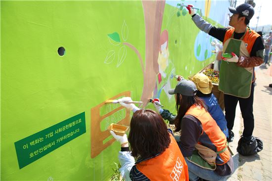 ▲호반건설 임직원들이 지난 29일 시흥 매화동에서 벽화 그리기 봉사활동을 펼치고 있다.