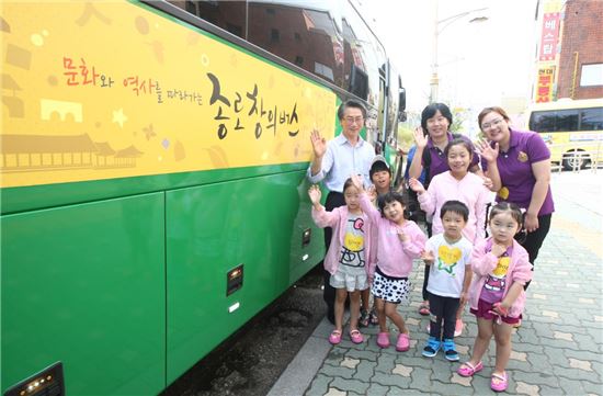 365종로창의버스 앞에서 김영종 구청장이 참가 어린이들과 포즈를 취하고 있다.