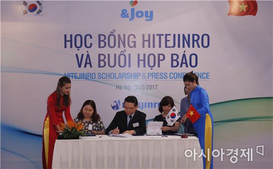 지난 5일 베트남 하노이에서 하이트진로 김인규 사장(가운데)이 하노이대학교와 하노이외국어대학교 교수들과 함께 장학금 수여 관련 양해각서(MOU)에 서명하고 있다.(하이트진로 제공)