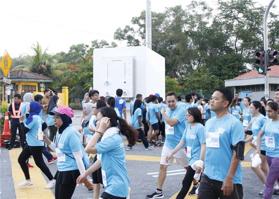 말레이시아에서 열린 '코웨이 런' 마라톤 대회에서 참가자들이 대형 코웨이 정수기를 통해 시원하고 깨끗한 물을 마시며 갈증을 해소하고 있다.