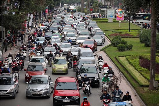 하노이 시내 중심가 도로 위를 달리는 자동차와 오토바이들