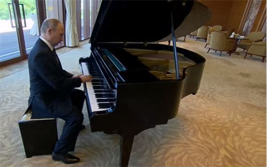 14일(현지시간) 중국 베이징에 있는 국빈관 댜오위타이에서 블라디미르 푸틴 대통령이 그랜드 피아노에 앉아 연주하는 모습. 사진=유튜브 영상 캡처
