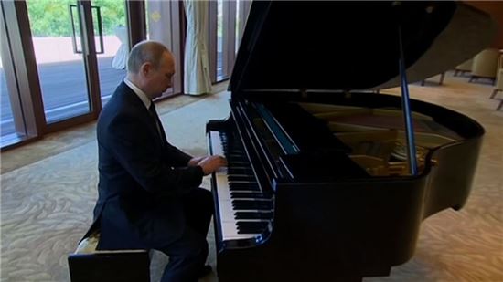 차분한 자세로 앉아 피아노를 연주하는 블라디미르 푸틴 러시아 대통령의 모습. 사진 = CNN 화면 캡쳐