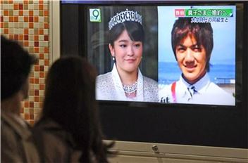 16일 밤 일본 도쿄(東京) 거리에서 행인들이 아키히토(明仁) 일왕의 손녀인 마코(眞子) 공주(25)가 결혼한다는 뉴스를 보고 있다. 도쿄(일본)=AP연합뉴스
