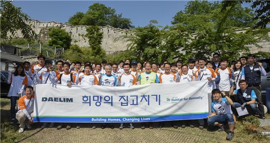 김한기 대림산업 사장(앞줄 중앙)을 포함한 대림그룹 임직원들이 17일 실시한 '희망의 집 고치기 활동'을 기념해 단체사진을 찍고 있다.(사진: 대림산업)