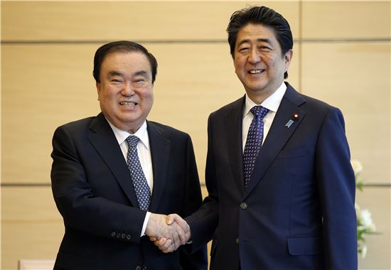 문재인 정부의 첫 일본 특사로 파견된 문희상 전 국회부의장이 18일 아베 신조 총리를 만나 악수하고 있다. 사진=AP연합