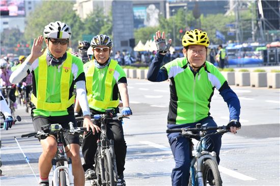 이재명 성남시장(오른쪽)이 금강산 관광재개를 위한 자전거 대행진에 동참해 자전거를 타고 가면서 손을 흔들고 있다. 
