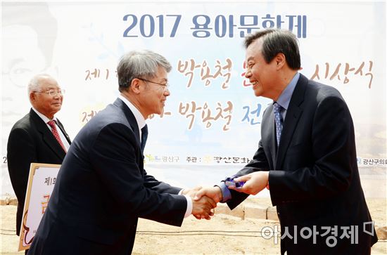 지난 20일 용아생가에서 개최한 제1회 용아박용철문학상 시상식에서 수상자 도종환 시인(오른쪽)과 민형배 광산구청장이 악수하고 있다.