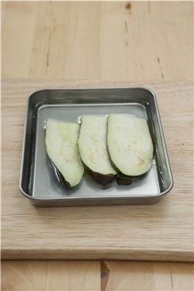 1. 가지는 반으로 갈라 0.5cm 두께로 길쭉하게 슬라이스 하여 소금을 뿌려 살짝 절인 다음 물기를 제거한다. 