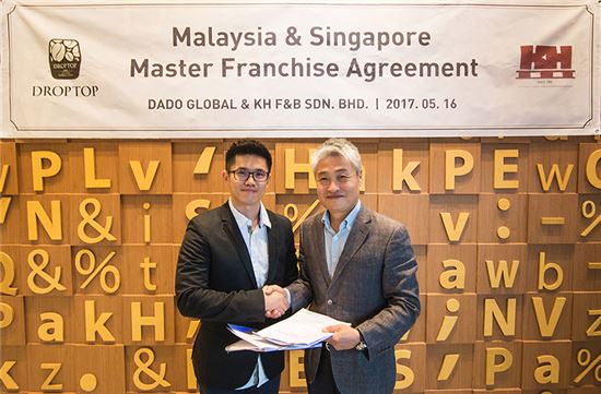 추아승와이(Chua Seng Wai, 왼쪽)와 카페드롭탑 홍탁성 대표가 말레이시아, 싱가포르 전 지역 마스터 프랜차이즈 계약을 체결하고 기념촬영을 하고 있다. 

