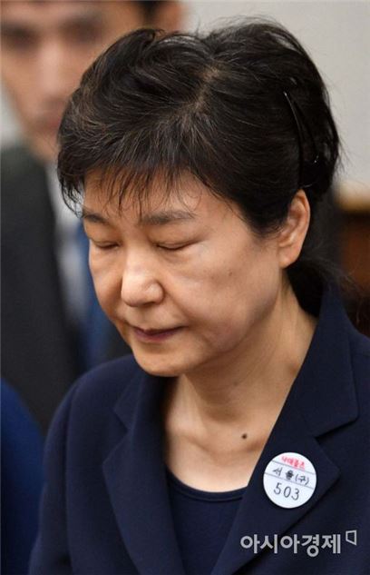 박근혜 전 대통령이 23일 오전 자신의 첫 공판에서 피고인석에 앉은 채 눈을 감고 공판이 시작되기를 기다리고 있다. 옷깃에 착용한 배지에 '나대블츠'라는 글자와 '503'이라는 자신의 수인번호가 찍혀있다./사진=아시아경제