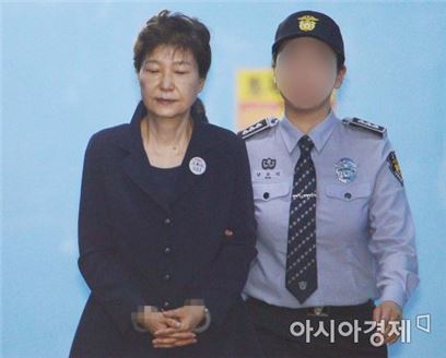 구속 기소된 박근혜 전 대통령이 23일 서울중앙지법에서 열린 첫 정식재판에 참석하기 위해 호송차에서 내려 이동하고 있다. 