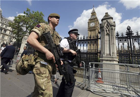 24일(현지시간) 영국 런던 국회의사당 주변에서 무장군인이 경찰과 함께 경계 근무를 서고 있다. 앞서 테리사 메이 영국 총리는 맨체스터 테러 이후 테러경보를 최고 단계인 '위기(critical)' 수준으로 격상하고 주요 도시와 장소에 군병력을 배치했다. (사진=AP연합)