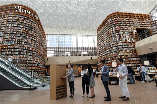 30일 강남구 삼성동 스타필드 코엑스몰에 사전 개장한 복합 문화공간 '별마당 도서관'에서 시민들이 도서를 기증하고 있다.




