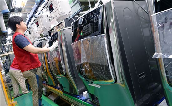 LG전자 직원이 31일 창원2공장에서 제조된 드럼세탁기를 검사하고 있다. 