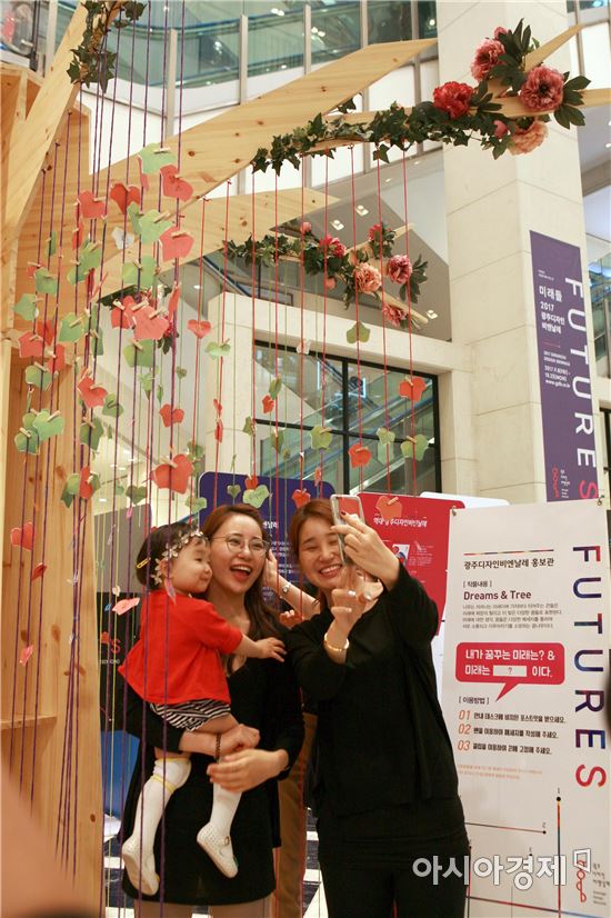 1일 오전 광주신세계백화점 1층에 마련된 ‘2017광주디자인비엔날레’ 홍보관을 찾은 시민들이 미래 꿈나무에 메시지를 붙이고 있는 모습. 