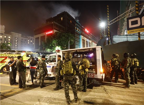 2일 새벽 총격·방화 사건이 발생한 필리핀 마닐라의 '리조트 월드 마닐라' 앞에 군인들과 구조대원이 서 있다. (사진=AP연합뉴스)