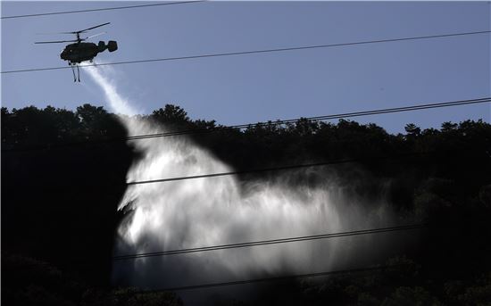 2일 오전 전일 대형 산불이 발생한 서울 노원구 수락산에서 소방헬기가 물을 뿌리며 잔불을 정리하고 있다. 사진 = 연합뉴스