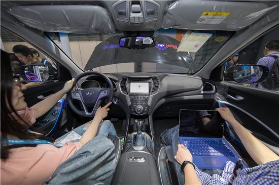 지난 6월 7일 중국 상해 신국제엑스포센터에서 개막한 'CES 아시아' 바이두 부스에서 관람객들이 현대차 중국형 싼타페에 시범적용된 ‘바이두 맵오토’와 ‘두어 OS 오토’를 체험하고 있다.