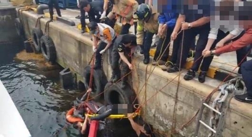 해경이 물에 빠진 여객선사 직원을 구조하고 있다. / 사진=연합뉴스(제주해양경비안전서 제공)