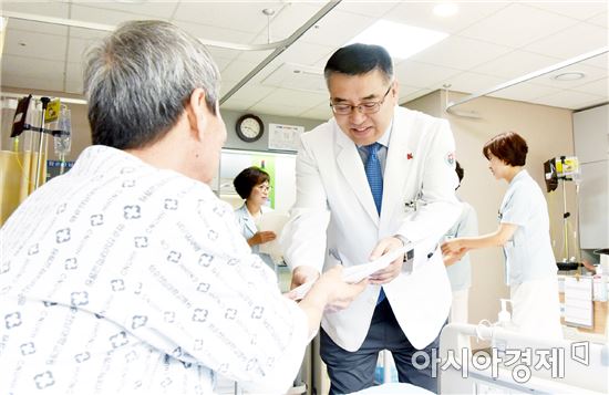 김형준 병원장이 ‘간호·간병 통합서비스 병동’개소식 기념품을 입원중인 환자에게 전달하고 있다.