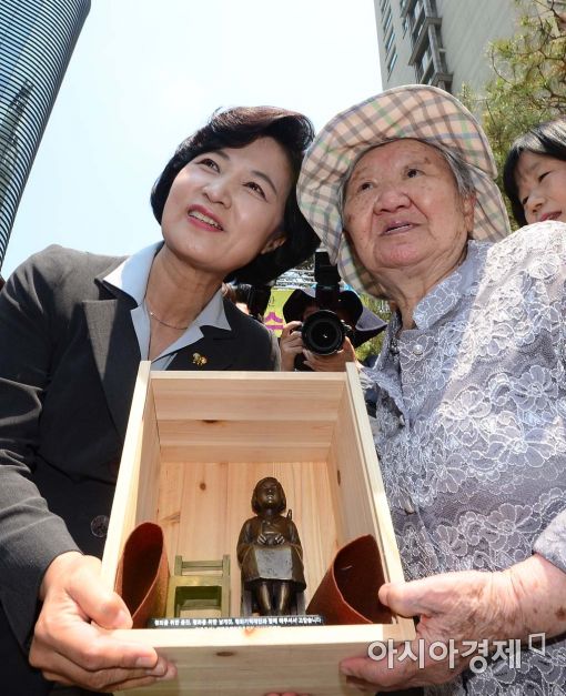 지난 6월 서울 종로구 평화의 소녀상 앞에서 열린 제1287차 일본군 위안부 문제 해결을 위한 정기 수요시위에서 길원옥 할머니(오른쪽)가 추미애 더불어민주당 대표(왼쪽)에게 평화의 소녀상 인형을 전달하고 있다. 
