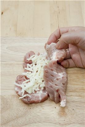 3. 피자 치즈를 한 줌 얹고 고기 한 장을 위로 얹어 모서리부터 두드려 고기끼리 접착되도록 한다.