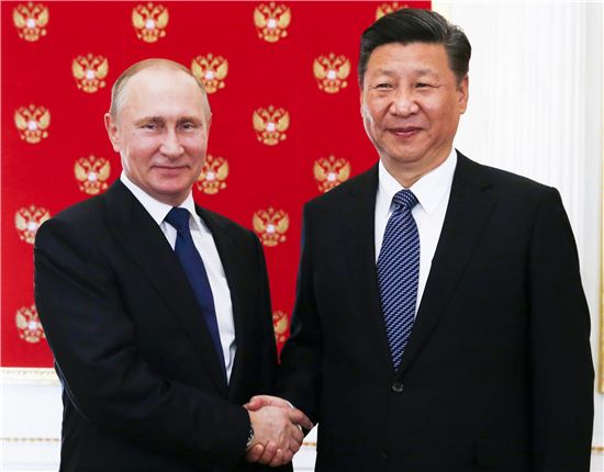 시진핑 중국 국가주석(오른쪽)이 블라디미르 푸틴 러시아 대통령과 만나 악수하고 있다.[사진=AP연합]