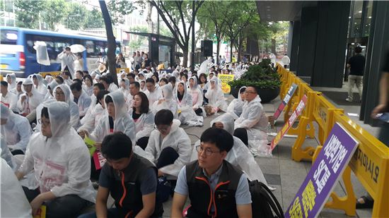 전국사무금융서비스노동조합 SK증권 지부 조합원들이 6일 오후 서울 종로구 SK그룹 본사 앞에서 집회를 열고 있다. 이들은 비가 내리는 가운데서도 우비를 챙겨 입고 자리를 지켰다. (사진=권성회 기자)