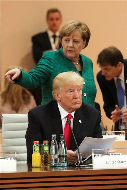 도널드 트럼프 미국 대통령과 앙겔라 메르켈 독일 총리가 8일(현지시간) 독일 함부르크의 주요 20개국(G20) 정상회의 실무회의에 참석해 서로 엇갈린 시선을 던지고 있다. 함부르크(독일)=AP연합뉴스
