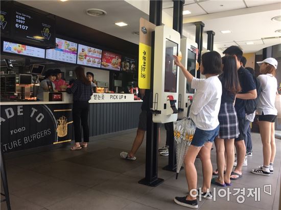 맥도날드의 무인결제기인 디지털 키오스크 앞에서 주문하는 사람들의 모습