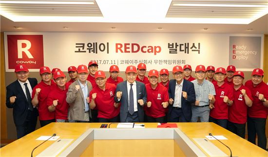 이해선 코웨이 대표(앞줄 왼쪽 여섯 번째)가 서울 중구 본사에서 열린 '레드캡' 발대식에 참석해 임직원들과 '고객에게 즉시 달려간다'라는 의미를 담은 모습으로 기념촬영을 하고 있다. 