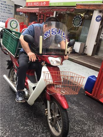 고양시 원당전통시장 직원이 주문 상품을 오토바이로 배달하고 있다. 