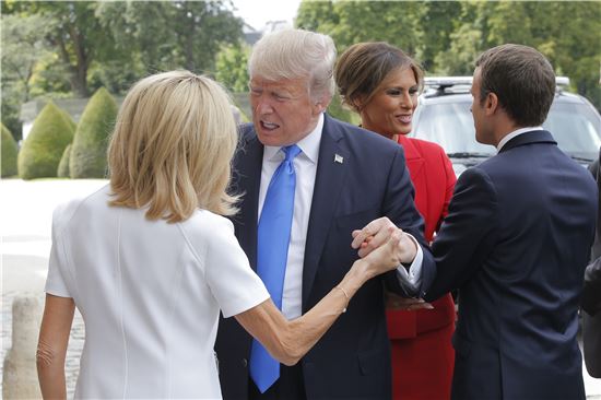 도널드 트럼프 미국 대통령이 13일(현지시간) 프랑스 영부인 브리짓 마크롱 여사의 손을 잡은 채 대화하고 있다. (사진=AP연합뉴스)
