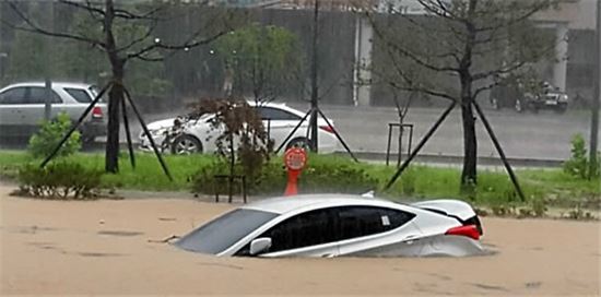 16일 오전 청주시 휴암동 곰두리체육관 인근 도로에 집중호우로 물에 잠긴 차량 모습(사진=연합뉴스)