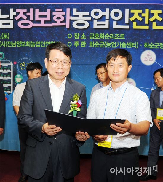 제9회 전남정보화농업인 전진대회에서 김성일 전남농업기술원장(왼쪽)이 김민석 씨에게 표창을 전달하고 기념사진을 촬영하고있다.