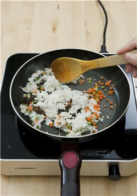 5. ④의 채소가 익으면 밥을 넣어 밥알이 으깨지지 않도록 주걱으로 자르듯이 고루 섞는다.