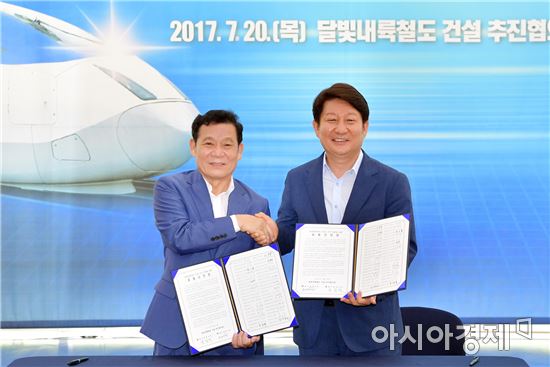 윤장현 광주광역시장과 권영진 대구광역시장이 20일 오전 광주시청 1층 시민숲에서 열린 문재인 정부의 영호남 상생 공약인 '달빛내륙철도 건설 추진협의회' 출범식에 참석해 공동선언문에 서명한 뒤 악수를 하고 있다./광주광역시 제공