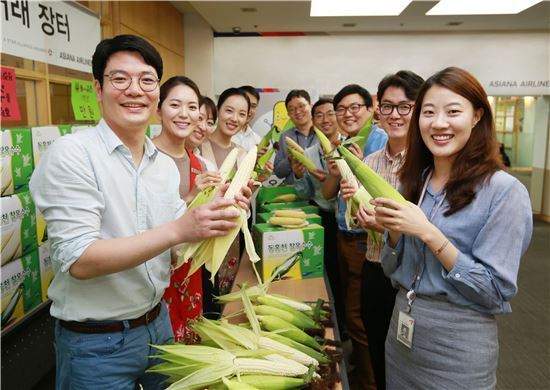20일 서울 강서구 아시아나타운에서 열린 '1촌 마을 특산품 직거래 장터'에서 아시아나항공 임직원들이 옥수수를 구입하고 있다. 