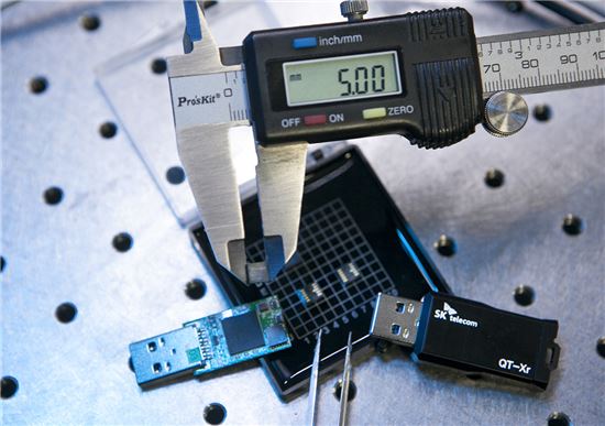 SK텔레콤 분당사옥에 위치한 '양자암호통신 국가시험망'에서 SK텔레콤 직원이 5x5mm 크기의 양자난수생성 칩을 측정하고 있다.

