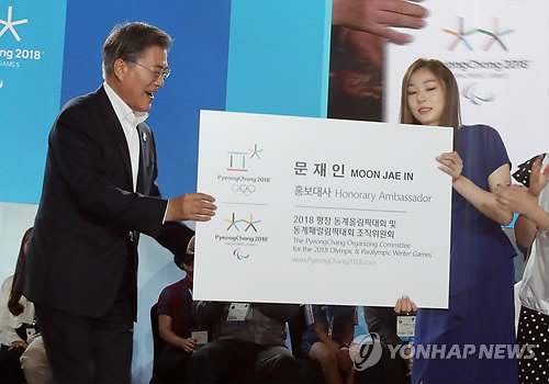 문재인 대통령이 24일 오후 평창 알펜시아 리조트에서 열린 'G-200, 2018, 평창을 준비하는 사람들' 평창 동계올림픽·패럴림픽 성공 다짐대회에 참석해 홍보대사인 김연아(전 피겨 국가대표 선수)로부터 대형 홍보대사 명함을 받고 있다. [이미지출처=연합뉴스]