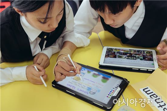 지난 6월 삼성전자에서 '스마트 스쿨'을 지원하는 한국외식과학고등학교 학생들이 태블릿과 전자칠판을 통해 스스로 검색하고 만들어가는 모둠 활동을 하고 있다.(제공=삼성전자)